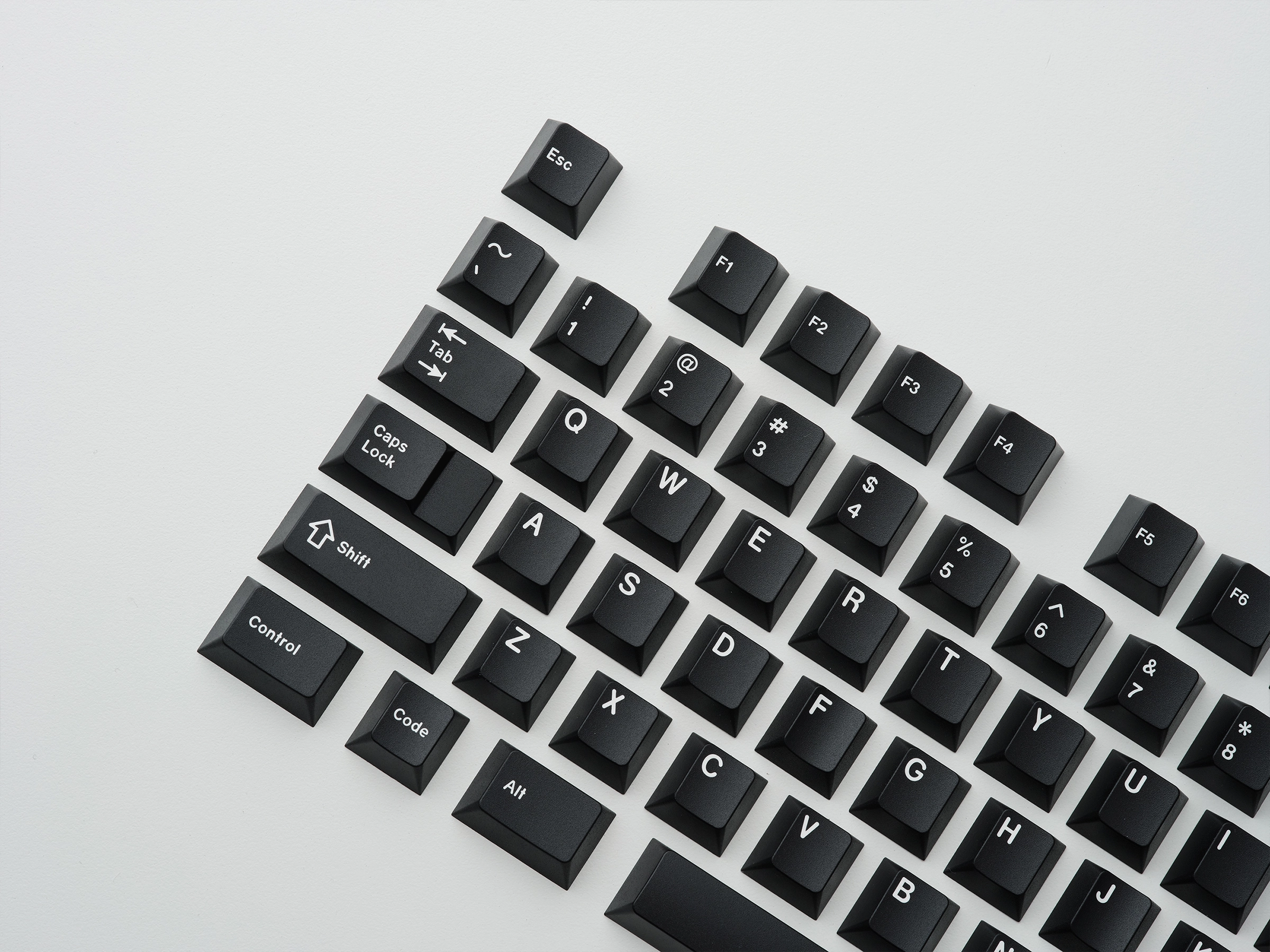 GMK CYL WOB (WHITE ON BLACK) KEYCAPS, left side of silver keyboard